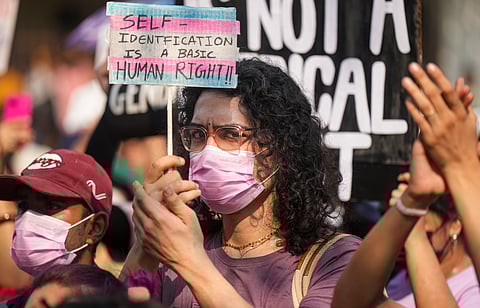 A member of the LGBTQIA+ community holds a placard during a protest against the passage of the Transgender Persons (Protection of Rights) Amendment Bill, 2026,
