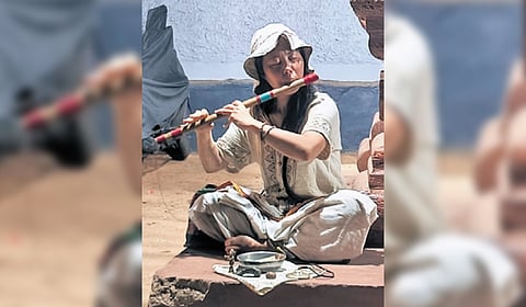 She does not seek alms, but keeps a plate with the idol of Lord Krishna and plays the flute.