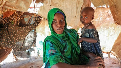 Nurto Madey, a mother displaced by drought, holds her daughter inside her makeshift hut at Ladan internally displaced persons (IDP) camp in Dolow, southern Somalia, Wednesday, March 25, 2026.