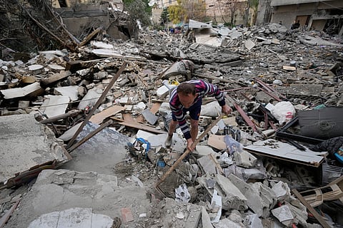 A man removes rubbles as he looks for missed stuff from his destroyed house that was hit in an Israeli airstrike in the southern port city of Tyre, Lebanon, Thursday, March 26, 2026.