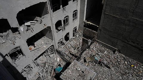 A building is damaged after a nearby residential building was hit in an overnight U.S.-Israeli strike in Tehran, Friday, March 27, 2026.