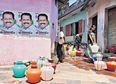 Women queue up with pots to collect water for their households at Kottappuram in Vizhinjam