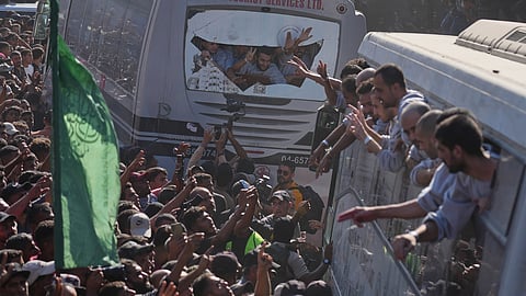 People gather to greet freed Palestinian prisoners arriving on buses in the Gaza Strip after their release from Israeli jails under a ceasefire agreement between Hamas and Israel, outside Nasser Hospital in Khan Younis, southern Gaza Strip, Monday, Oct. 13, 2025.