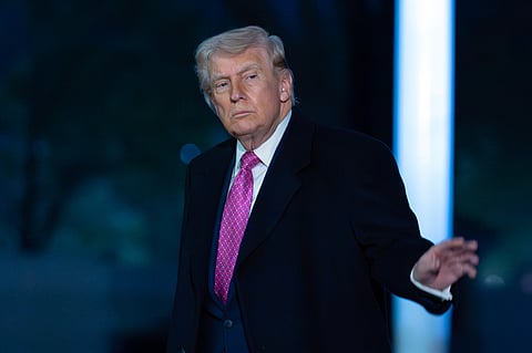 President Donald Trump waves to the media as he walks on the South Lawn upon his arrival to the White House, Sunday, March 29, 2026, in Washington.