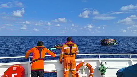 In this photo released by the Indonesian National Search and Rescue Agency (BASARNAS), crew look on as a rescue ship approaches a raft to evacuate the survivors from a boat that sank on Monday, in the waters off Taliabu Island, Indonesia, Tuesday, March 31, 2026.