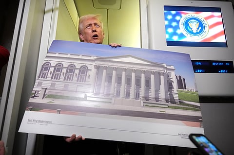 President Donald Trump holds a rendering of the proposed new East Wing of the White House as he speaks to reporters aboard Air Force One en route from West Palm Beach, Fla., to Joint Base Andrews, Md., Sunday, March 29, 2026.