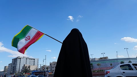 A woman waves an Iranian flag during a campaign in support of the government at the Enqelab-e-Eslami, or Islamic Revolution, square in downtown Tehran, Iran, Monday, March 30, 2026.