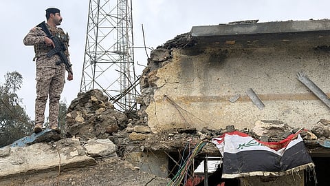 An Iraqi soldier stands guard atop a damaged building at the Iraqi army base in Habbaniyah after it was hit by an airstrike Wednesday, in Anbar province, Iraq, Thursday, March 26, 2026.