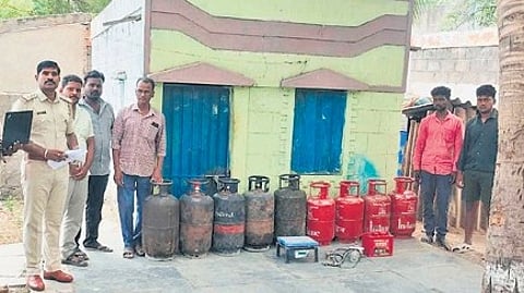 Police with LPG cylinders seized during a raid in Ballari