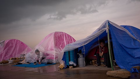 Children displaced from Beirut's southern suburb of Dahiyeh shelter from the rain inside their tents along the coast in Beirut, Lebanon, Thursday, March 26, 2026.