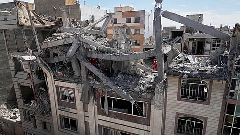 First responders inspect a residential building hit in an earlier US-Israeli strike in Tehran, Friday, March 27, 2026.