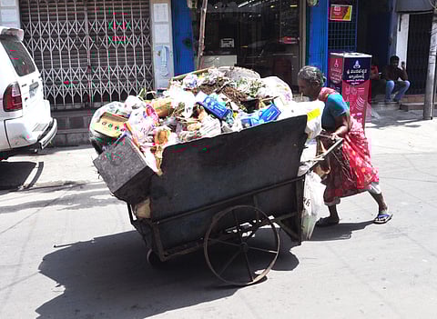 A woman disposes of a cartload of plastic waste in Visakhapatnam.
