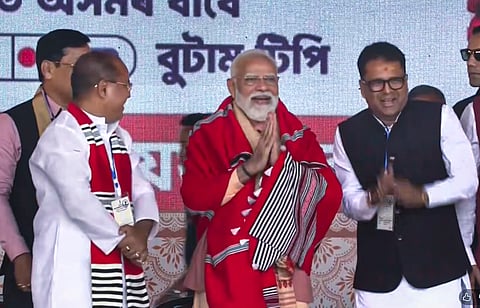 Prime Minister Narendra Modi greets a gathering during a public meeting, in Gogamukh, Assam.