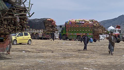 Afghan refugees walk next to trucks loaded with their family's belongings as they wait for registration to leave for their homeland outside a repatriation centre in Landi Kotal, a town in Pakistan's Khyber district bordering Afghanistan, Wednesday, April 1, 2026.