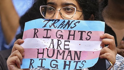 A supporter of the LGBTQIA+ community holds a placard during a protest against the passage of the Transgender Persons (Protection of Rights) Amendment Bill, 2026.