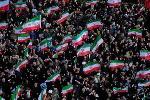 Mourners wave Iranian flags in Tehran, Iran, Wednesday, April 1, 2026, as they gather during a funeral procession for Alireza Tangsiri, head of Iran's Islamic Revolutionary Guard Corps Navy, and others killed in Israeli strikes in late March.