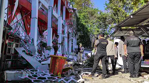 Police officers look at a building of the North Sumatra's National Sports Committee of Indonesia (KONI) damaged following a severe 7.4-magnitude offshore quake in Manado, North Sulawesi on April 2, 2026.