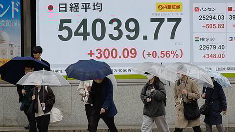 Perople walk in front of an electronic stock board showing Japan's Nikkei index at a securities firm Thursday, April 2, 2026, in Tokyo.