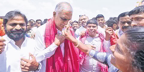 A BRS supporter applies tilak on the forehead of former minister T Harish Rao during his visit to Kodangal on Friday