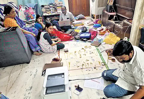 Sleuths of the Anti-Corruption Bureau (ACB) inspect cash, gold and documents seized during surprise raids at sub-registrar offices and residences of officials in Hanamkonda district on Friday