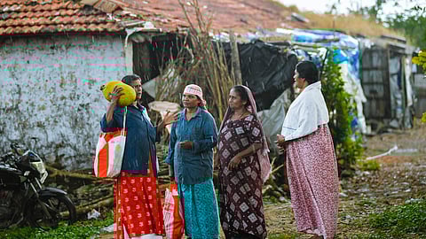 Plantation workers outside dilapidated estate quarters at Vagamon.