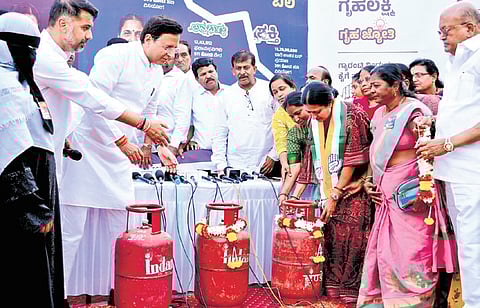 AICC General Secretary Randeep Singh Surjewala makes a point by garlanding gas cylinders at a campaign programme in Davanagere on Saturday