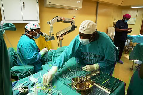 An ophthalmologist performs cataract surgery while an assistant hands him surgical instruments during a marathon event, in Tsakane, South Africa, Saturday, March 28, 2026.