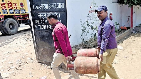 People seen carrying LPG Cylinder from a filling station at South Delhi n Friday.