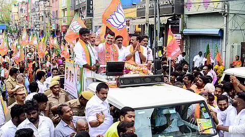 Maharashtra Chief Minister Devendra Fadnavis, centre, greets the gathering during an election campaign in support of BJP candidate for Madurai South constituency.