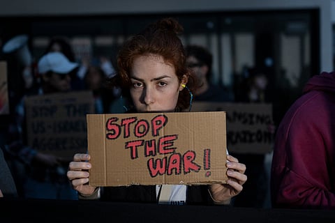 Israeli left-wing activists hold placards during a protest outside the US Embassy in Tel Aviv on April 6, 2026, against the ongoing war with Iran.