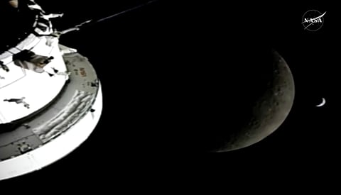 In this image from video provided by NASA, the Orion Spacecraft, the Earth and the Moon are seen from a camera as the Artemis II crew and spacecraft travel farther into Space, Monday, April 6, 2026.