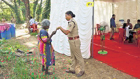 Sushamavathi, an elderly voter, enquiring with a police officer about the voting procedures, at Ramanthuruth in Kochi on Wednesday. This booth has only 19 voters and a temporary shed has been erected for voting.