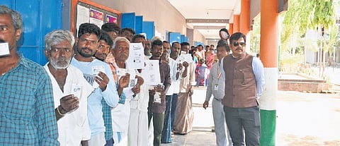 People wait to vote outside a polling booth in Davanagere South on Thursday