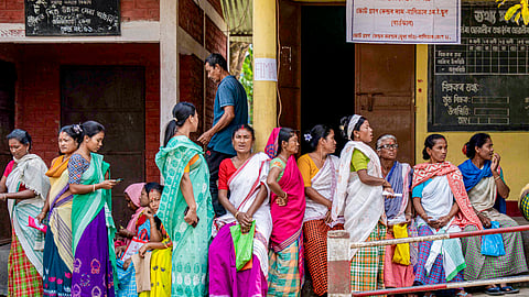 People gather outside a polling station before casting their votes in the Assam Assembly elections, at Bokakhat in Golaghat district, Thursday, April 9, 2026.