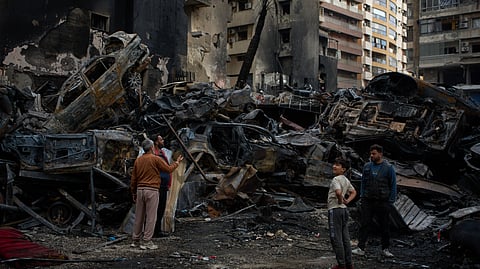 Residents gather near charred cars and buildings, at the site of Wednesday's Israeli airstrike, in Beirut, Lebanon, Friday, April 10, 2026.
