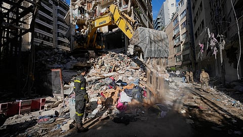 A Lebanese civil defense worker looks on as an excavator operates on the rubble of a building destroyed in an Israeli airstrike a day earlier in Beirut, Lebanon, Thursday, April 9, 2026.
