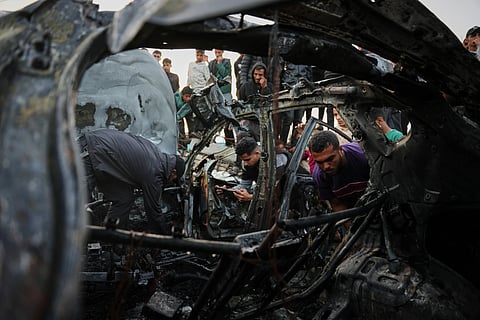 Palestinians inspect a vehicle struck by an Israeli airstrike in the Maghazi refugee camp in the central Gaza Strip, Saturday, April 4, 2026.