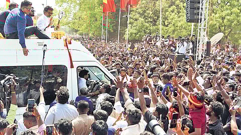 TVK chief Vijay waves to supporters at the campaign venue in Karaikudi on Friday. Fans gathered in huge numbers along the route in Melur, SS Kottai, Tiruppathur, and Kundrakudi.