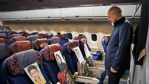 Iranian Parliament Speaker Mohammad Ghalibaf stands in front of empty seats arranged with belongings of victims of the Minab school strike.