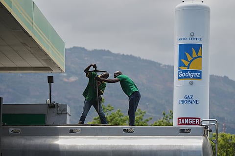Gas station employees prepare to fill a tank with gas in Port-au-Prince, Haiti, Tuesday, April 7, 2026.