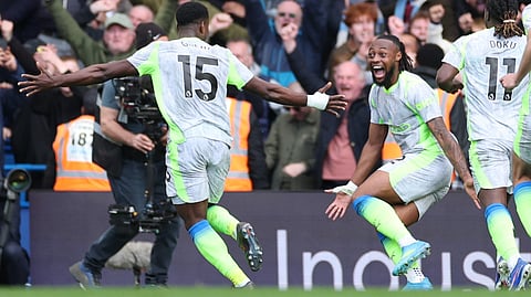 Manchester City's Marc Guehi, left, and Jeremy Doku celebrate after scoring during the Premier League soccer match between Chelsea and Manchester City in London, Sunday, April 12, 2026.