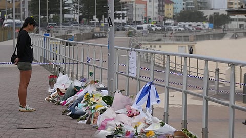 A woman stands at a flower tribute at Bondi Beach on Dec. 16, 2025, following Sunday’s shooting in Sydney, Australia.