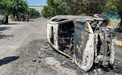 Wreckage of a car is seen after it was burnt during a protest by factory workers demanding a hike in wages, in Noida, Gautam Buddh Nagar district, Uttar Pradesh, Monday, April 13, 2026.