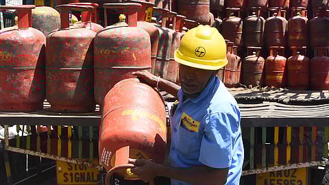 LPG gas cylinder delivery person taking away cylinders from a truck to deliver from Vatal Nagaraj Road (near Lulu Mall) in Bengaluru on Tuesday. Due to new regulations by the Central Government, commercial LPG has become scarce.