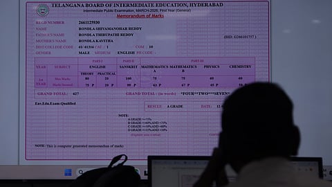 A man looks at the results of Intermediate exams as TGBIE announces the Intermediate Public Examination (IPE) results at Vidhya Bhavan in Hyderabad on Sunday.