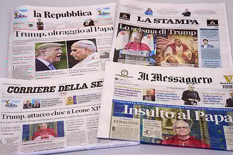 This picture, taken Tuesday, April 14, 2026, shows the front pages of some Italian newspapers reporting on comments by US President Donald Trump about Pope Leo XIV, with headlines using words such as "outrage", "shock attack", "insult", and Trump's schism".