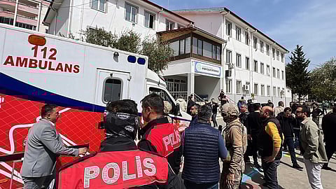 Turkish security forces and emergency staff stand in the courtyard of a secondary school where an assailant opened fire, in Kahramanmaras, Turkey, Wednesday, April 15, 2026.