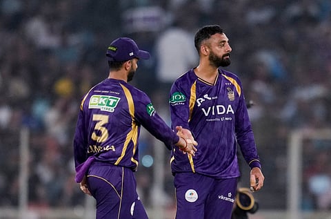KKR's captain Ajinkya Rahane, left, greets teammate Varun Chakaravarthy after taking the wicket of Gujarat Titans' Jos Buttler during the IPL 2026 T20 cricket match between Gujarat Titans and KKR on April 17, 2026.