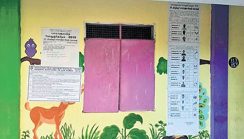 Election related notices pasted on the wall with paintings at a govt school
