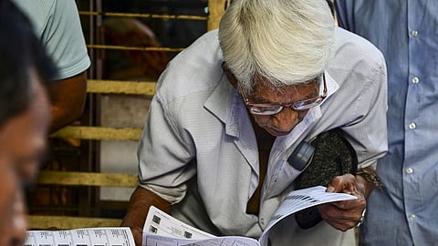 A voter checks his name in the list after the Election Commission published West Bengal's post-SIR electoral rolls in Kolkata